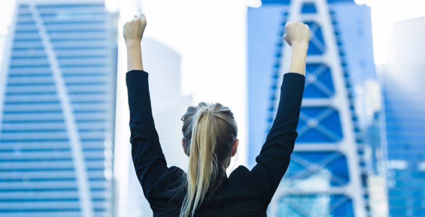 Business,Success,-,Celebrating,Businesswoman,Overlooking,The,City,Center,High-rises.