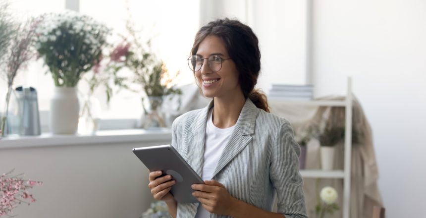 Happy,Young,Dreamy,Woman,Holding,Computer,Tablet,In,Hands,,Looking